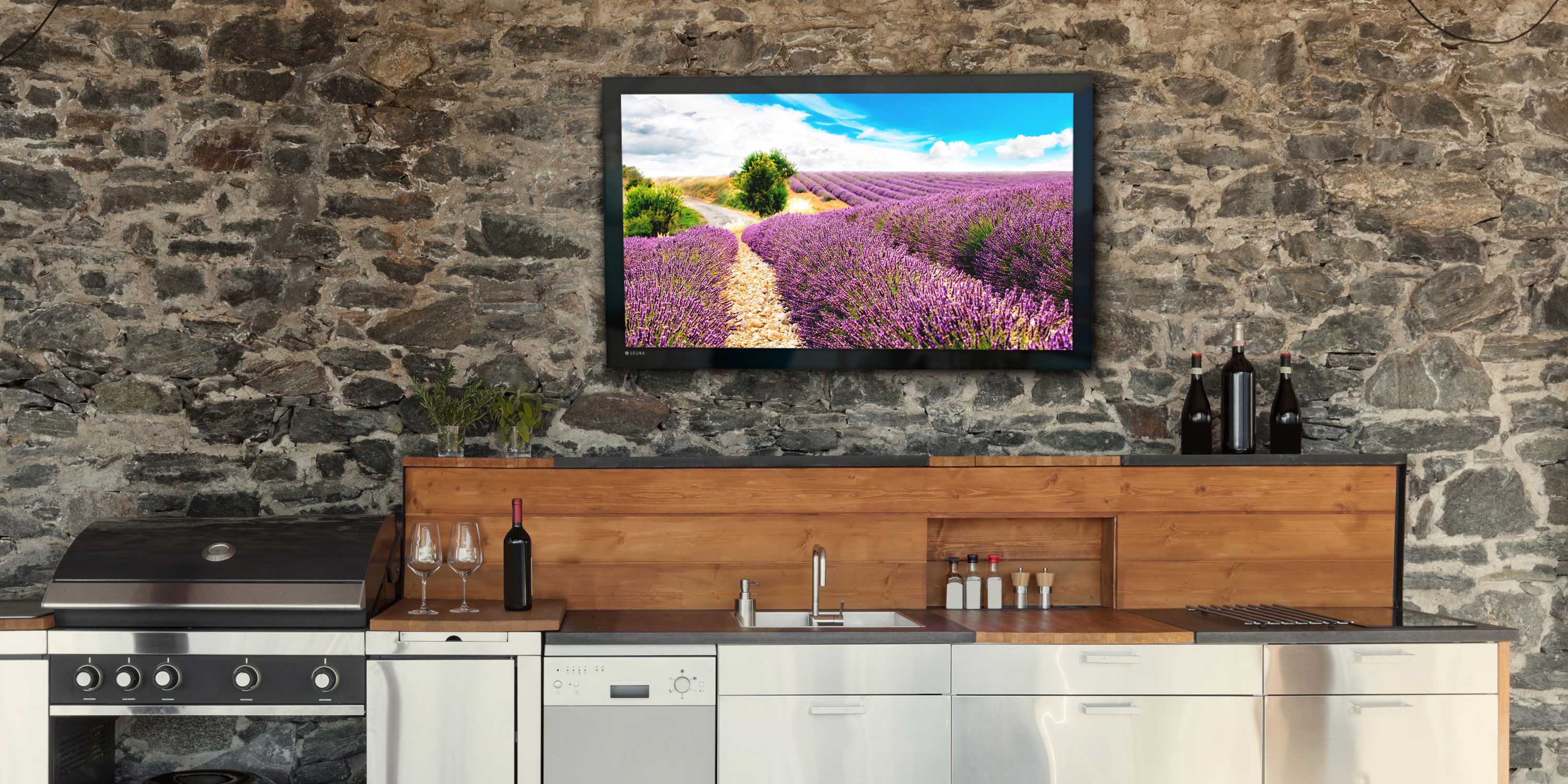 outdoor kitchen with tv on brick wall