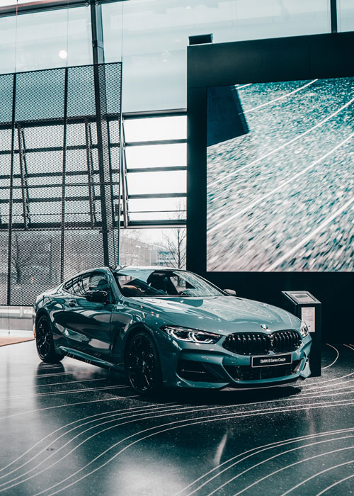A car in a commercial space with a video wall.