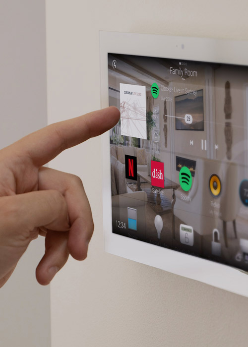 Hand tapping a Control4 wall control panel.