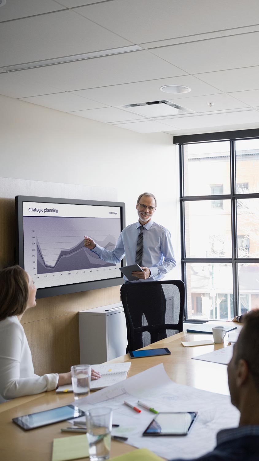 Man presenting data chart in a glass-walled meeting room
