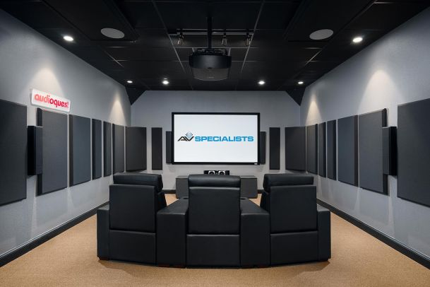 Theater room with projector, black recliners, and AV Specialists screen