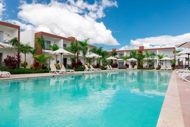 Resort-style swimming pool with lounge chairs and palm trees