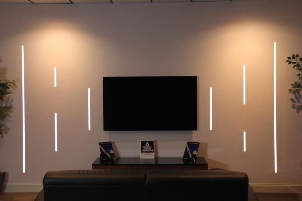 Modern showroom display with wall-mounted TV and decorative lights